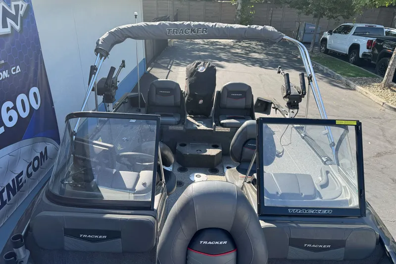 Slide: The Image of 2021 Tracker Pro Guide V-175 Combo boat with seating and windshield, parked outdoors. - 25