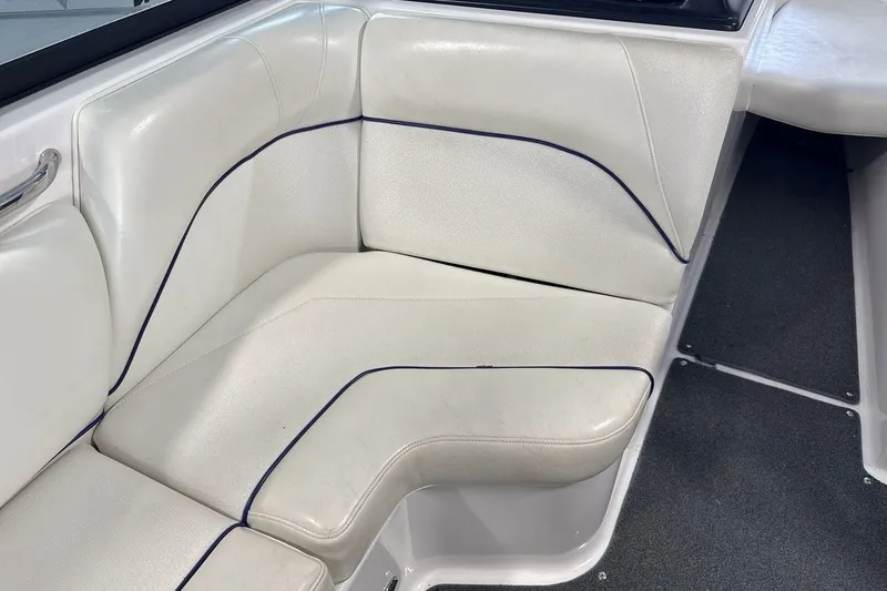 Slide: The Image of 2016 Moomba Mojo boat interior with white cushioned seating and dark trim accents. - 17
