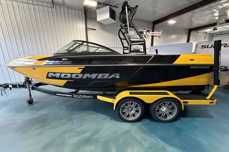 Slide: The Image of 2016 Moomba Mondo boat in black and yellow on a trailer, indoor showroom. - 2