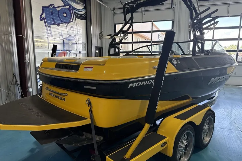 Slide: The Image of 2016 Moomba Mondo boat in showroom, yellow and black design, on trailer. - 5
