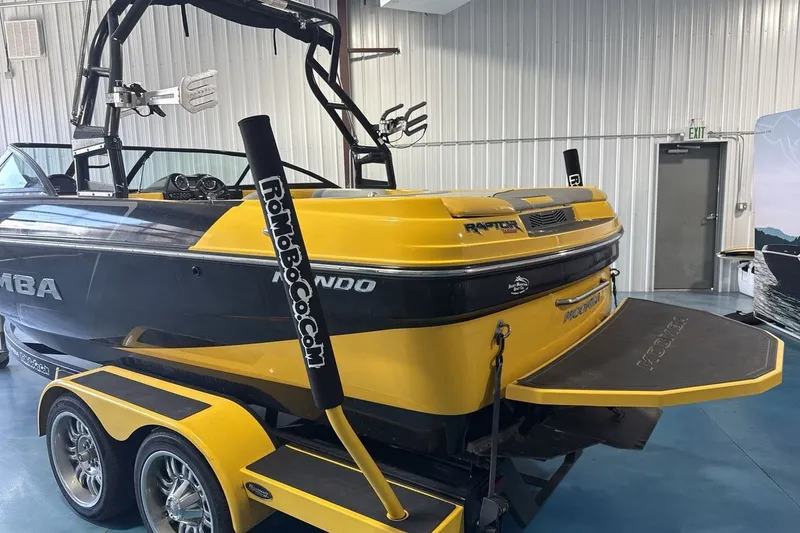 Slide: The Image of 2016 Moomba Mondo boat in showroom, yellow and black design, on trailer. - 3
