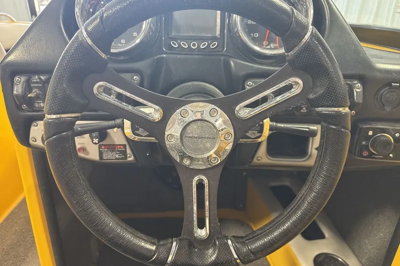 Slide: The Image of Steering wheel of a 2016 Moomba Mondo boat, featuring a sporty design and control panel. - 14