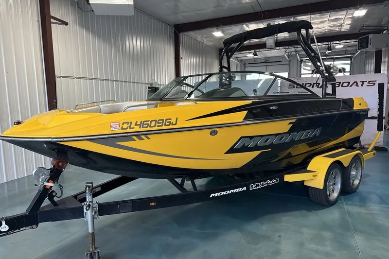 The Image of 2016 Moomba Mondo boat in a showroom, yellow and black design on trailer. - 1