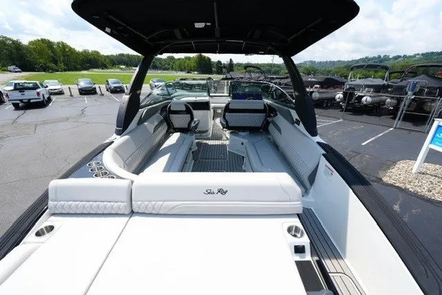 Slide: The Image of 2027 Sea Ray SLX 280 boat with spacious seating and sleek design in a parking lot. - 8