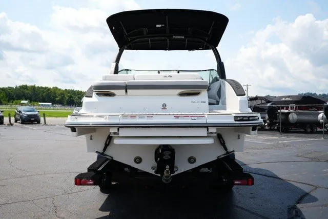 Slide: The Image of 2027 Sea Ray SLX 280 boat, rear view, parked on asphalt under a clear sky. - 6