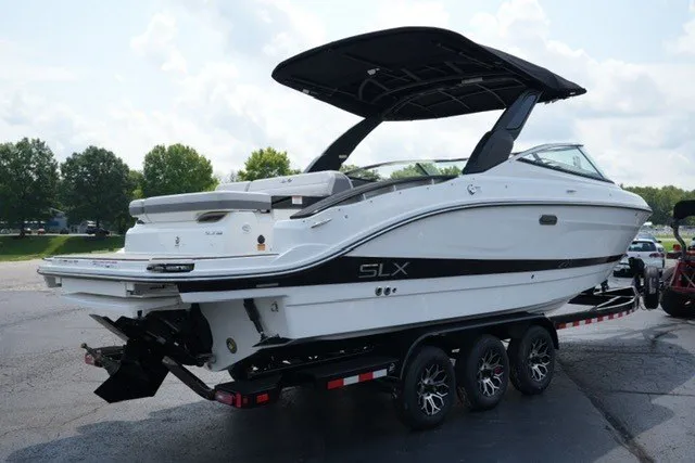 Slide: The Image of 2027 Sea Ray SLX 280 boat on trailer, sleek design, black canopy, parked outdoors. - 5