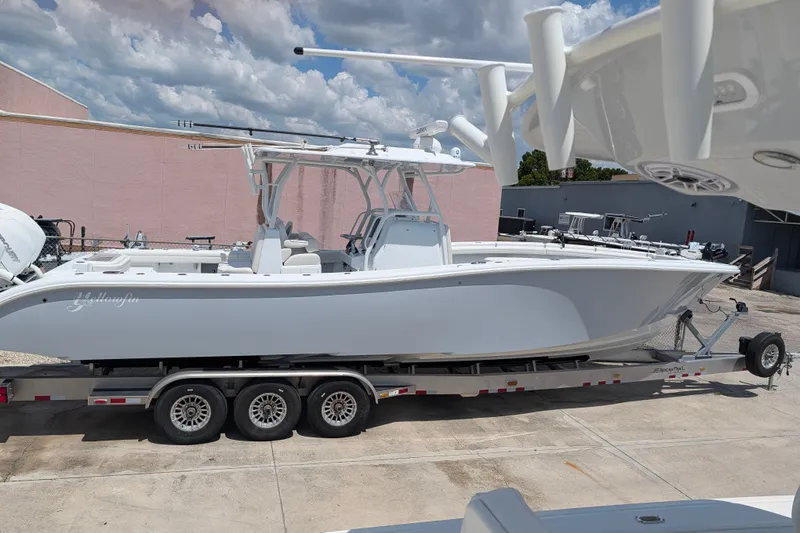 Slide: The Image of 2022 Yellowfin 36 Offshore boat on trailer, parked outdoors under cloudy sky. - 2