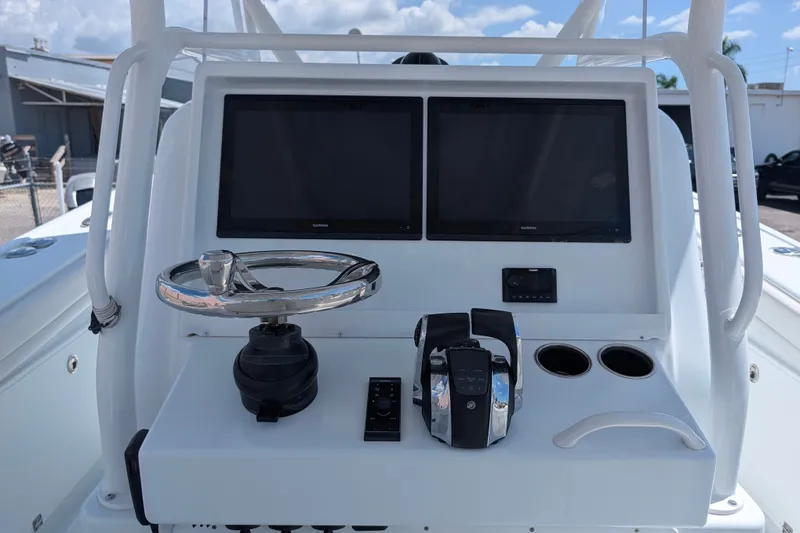 Slide: The Image of 2022 Yellowfin 36 Offshore boat dashboard with dual screens and steering wheel. - 15