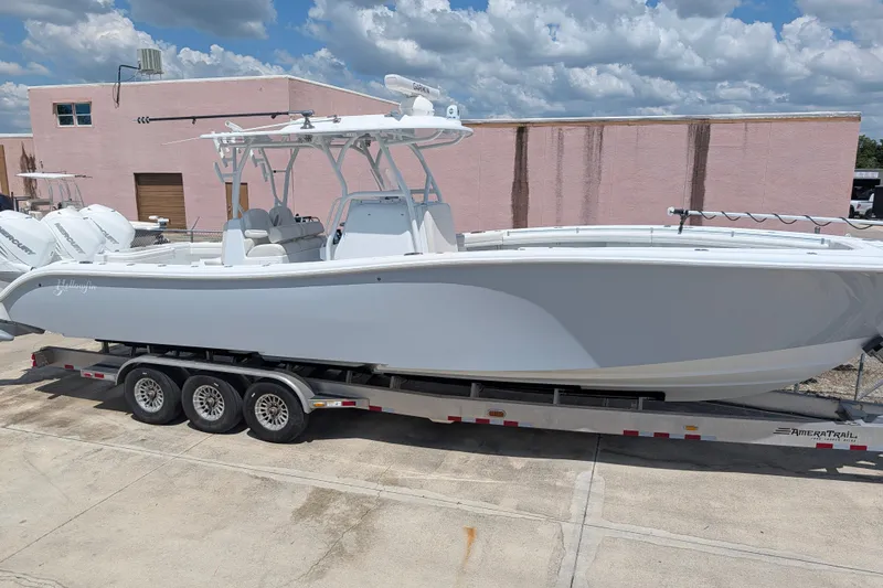 Slide: The Image of 2022 Yellowfin 36 Offshore boat on trailer, parked outdoors under cloudy sky. - 1