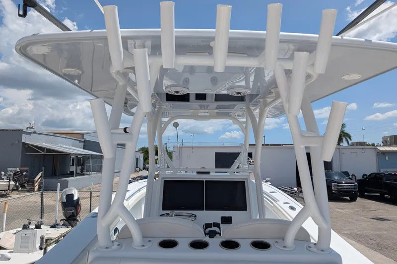 Slide: The Image of 2022 Yellowfin 36 Offshore boat with rod holders and dual screens, docked under a clear sky. - 18