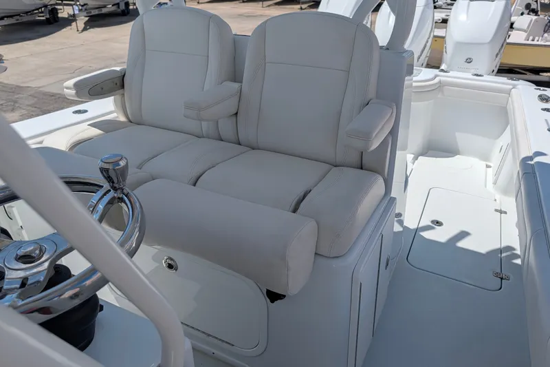 Slide: The Image of 2022 Yellowfin 36 Offshore boat interior with dual white captain's seats and steering wheel. - 16