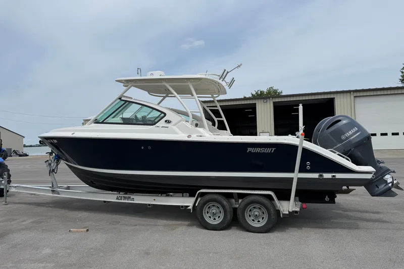 The Image of 2020 Pursuit DC 266 Dual Console boat on trailer, parked outdoors. - 0