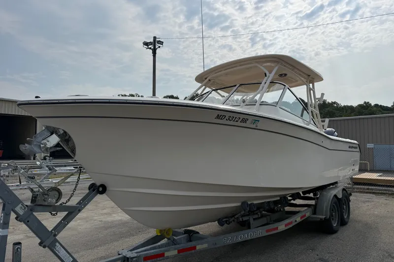 Slide: The Image of 2020 Grady-White Freedom 275 boat on trailer, parked outdoors under cloudy sky. - 1