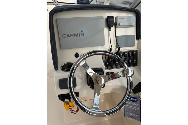 Slide: The Image of Steering wheel and Garmin display on 2020 Grady-White Freedom 275 boat dashboard. - 18