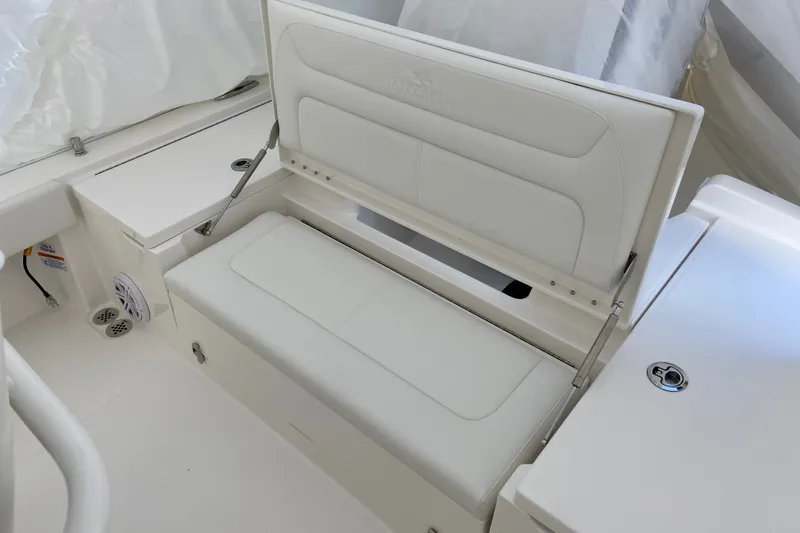 Slide: The Image of 2027 Regulator 24XO boat with open storage compartment and white cushioned seating. - 1