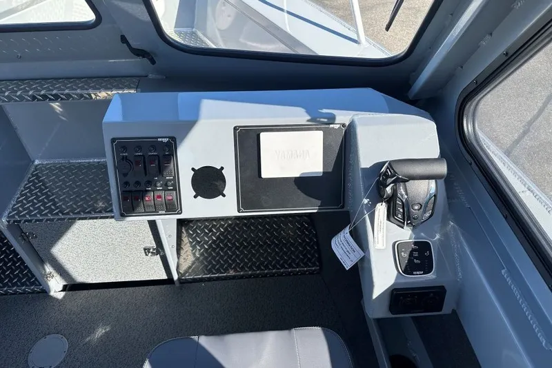 Slide: The Image of Interior helm of 2026 Hewescraft 240 Ocean Pro ET boat, featuring control panel and throttle. - 6