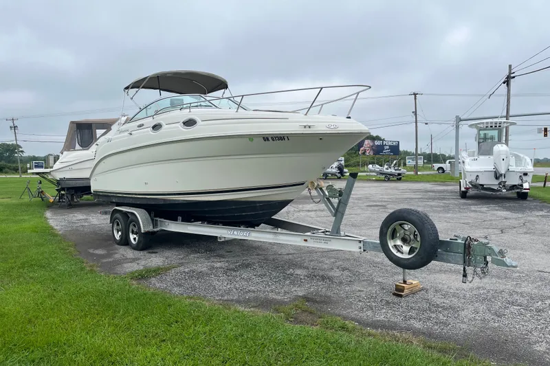 The Image of 2002 Sea Ray 240 Sundancer boat on trailer in outdoor setting. - 0