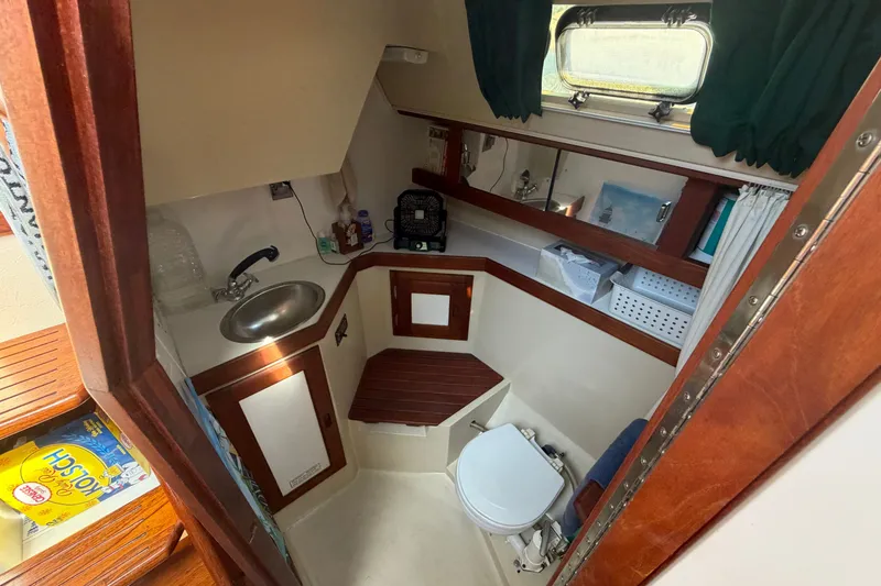Slide: The Image of 1987 Catalina 34 yacht bathroom with sink, toilet, and wooden cabinetry. - 48