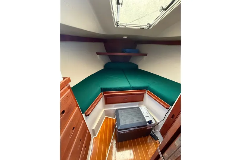 Slide: The Image of Cozy cabin interior of 1987 Catalina 34 sailboat with green bedding and wooden accents. - 46