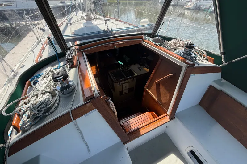 Slide: The Image of 1987 Catalina 34 sailboat cockpit with open hatch, ropes, and winches. - 18