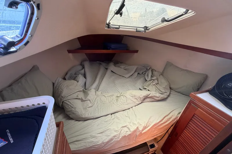 Slide: The Image of Cozy cabin interior of a 1987 Catalina 34 sailboat with a bed and porthole. - 45