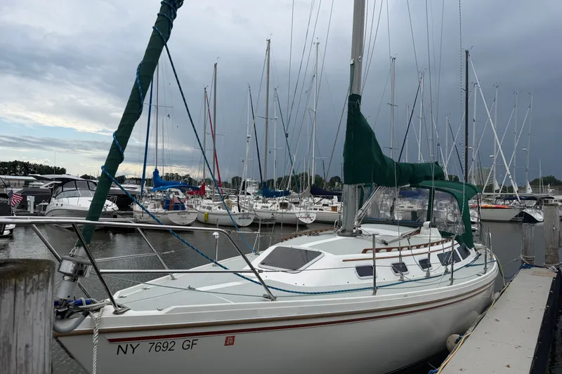 Slide: The Image of 1987 Catalina 34 sailboat docked at marina under cloudy sky. - 4