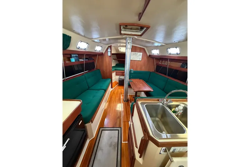 Slide: The Image of Interior of a 1987 Catalina 34 sailboat with green seating and wooden finishes. - 34