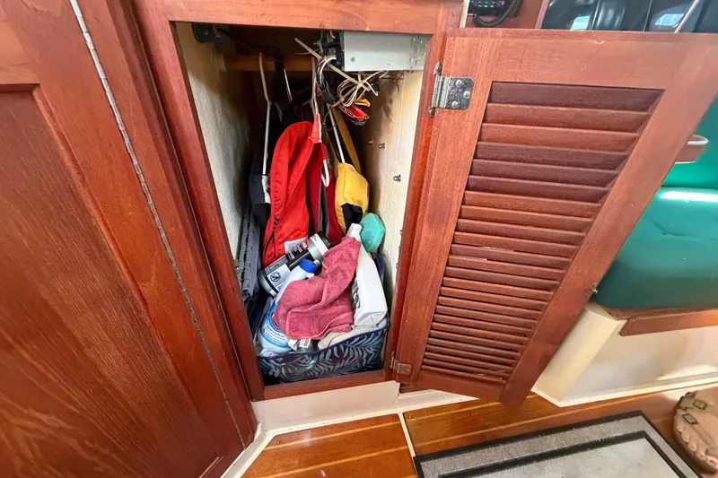 Slide: The Image of Open wooden cabinet on 1987 Catalina 34 sailboat, storing various items and gear. - 40