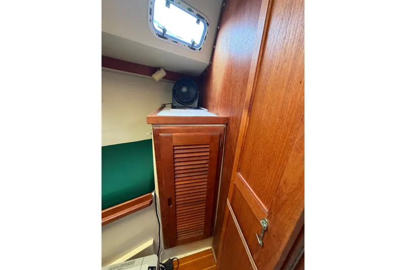 Slide: The Image of Interior of 1987 Catalina 34 sailboat with wooden cabinetry and green cushion. - 47