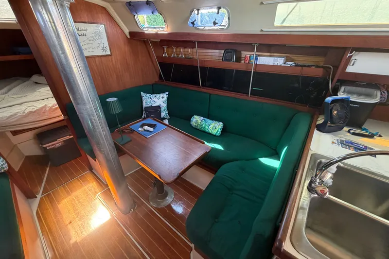 Slide: The Image of Interior of a 1987 Catalina 34 sailboat with green seating and wooden accents. - 44