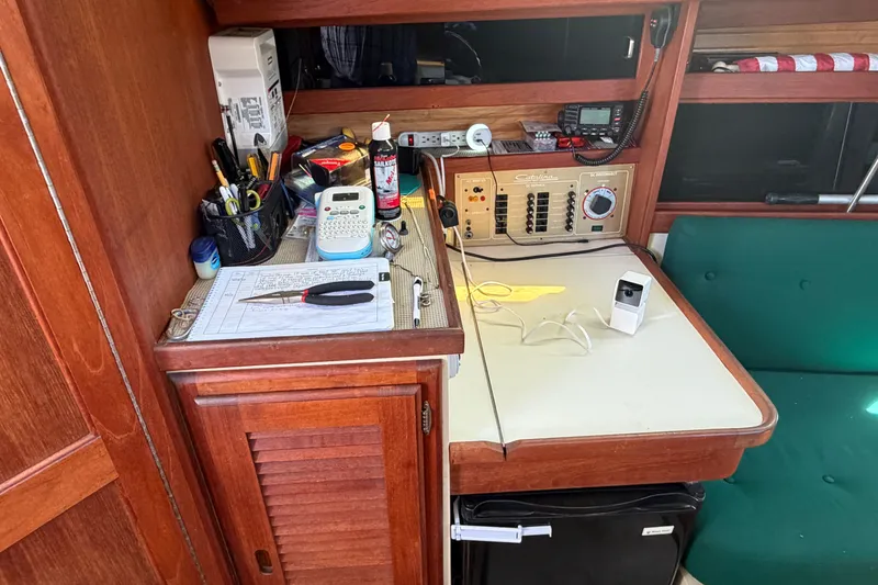 Slide: The Image of Navigation station inside a 1987 Catalina 34 sailboat with equipment and tools. - 39