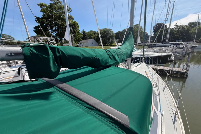Slide: The Image of Sailboat Catalina 34 (1987) docked, featuring green sail cover and deck canopy. - 9