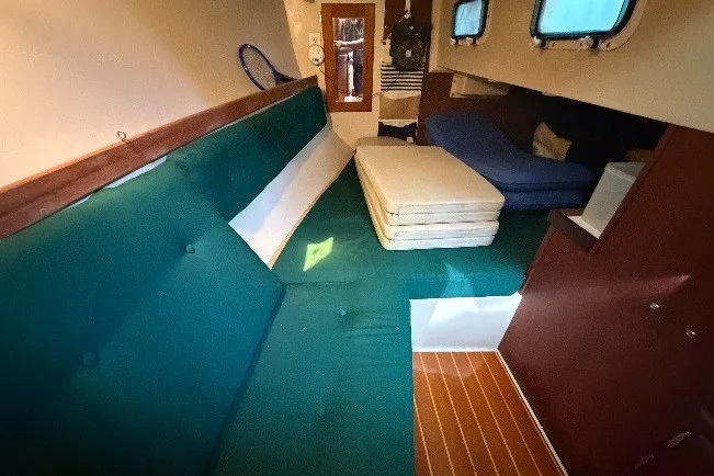 Slide: The Image of Interior of a 1987 Catalina 34 sailboat with green seating and wooden flooring. - 29