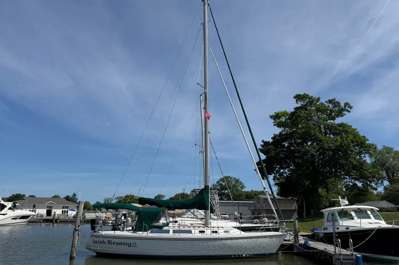Slide: The Image of 1987 Catalina 34 sailboat docked at marina under clear blue sky. - 2