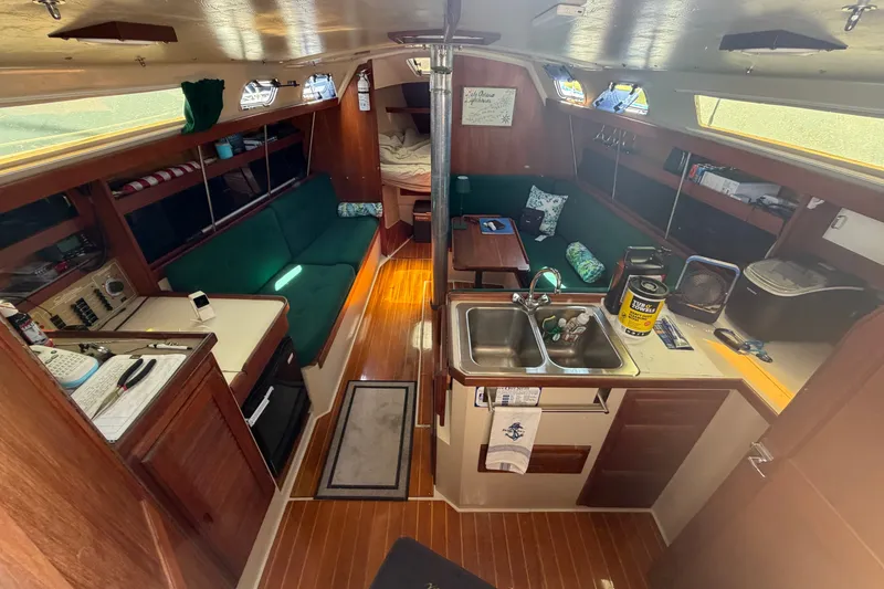 Slide: The Image of Interior of a 1987 Catalina 34 sailboat with cozy seating and compact kitchen area. - 25