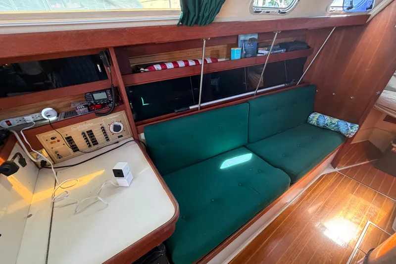 Slide: The Image of Interior of a 1987 Catalina 34 sailboat with green cushioned seating and navigation equipment. - 43