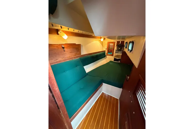 Slide: The Image of Interior of a 1987 Catalina 34 sailboat with teal seating and wooden accents. - 31