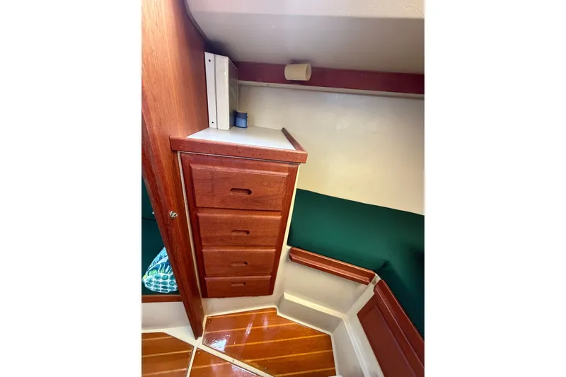 Slide: The Image of Interior of 1987 Catalina 34 sailboat with wooden drawers and green seating. - 32