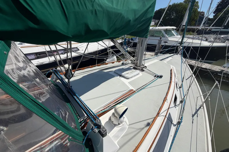 Slide: The Image of 1987 Catalina 34 sailboat deck with green cover, docked at marina. - 8