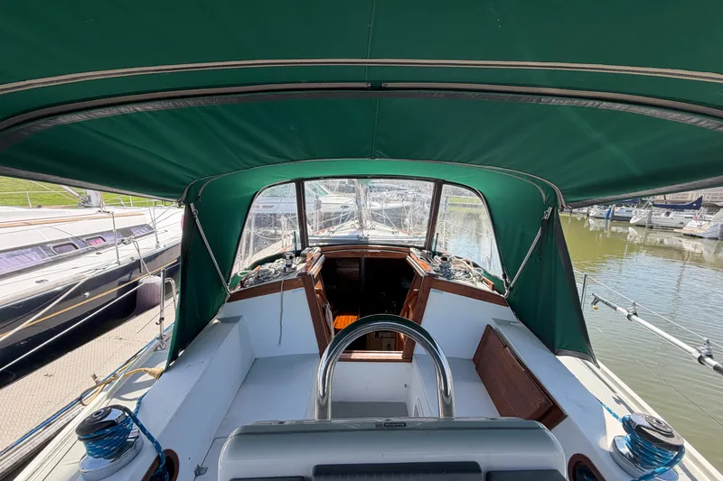 Slide: The Image of Cockpit view of a 1987 Catalina 34 sailboat with green canopy in marina. - 15