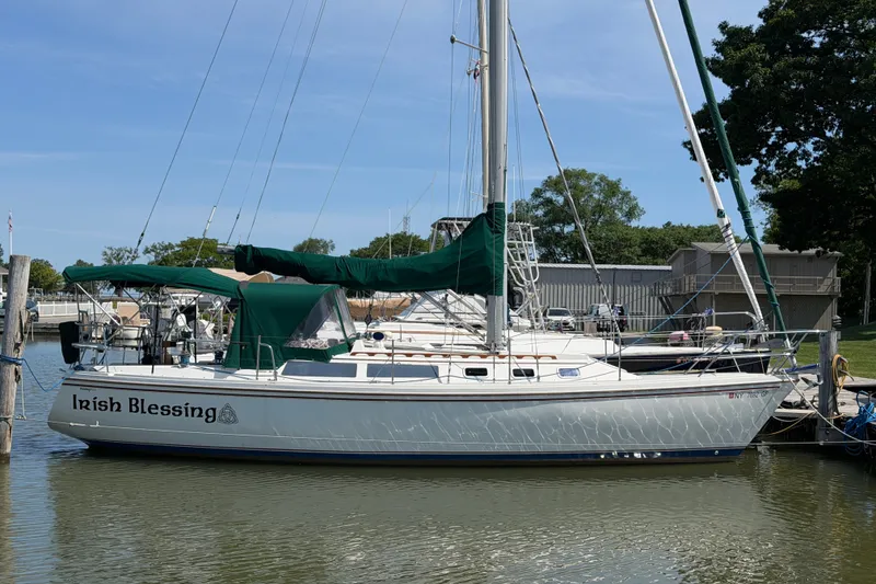 Slide: The Image of 1987 Catalina 34 sailboat named "Irish Blessing" docked in a marina. - 1