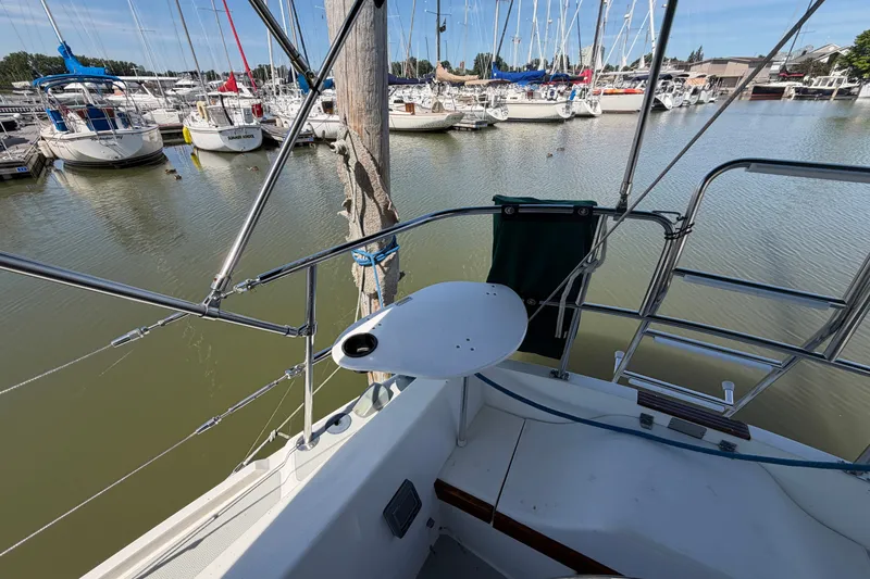 Slide: The Image of 1987 Catalina 34 sailboat docked in marina, surrounded by other boats. - 11