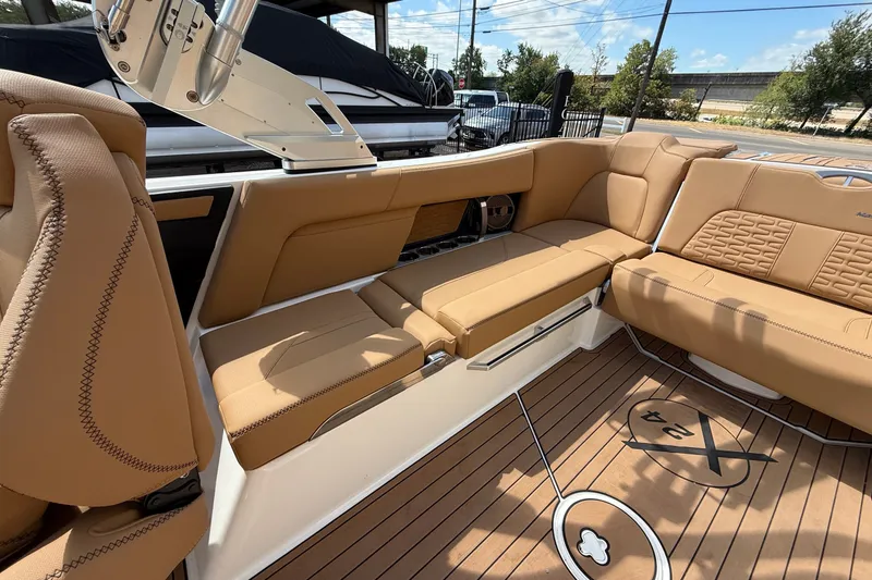 Slide: The Image of 2020 MasterCraft X24 boat interior with tan seating and teak flooring. - 11