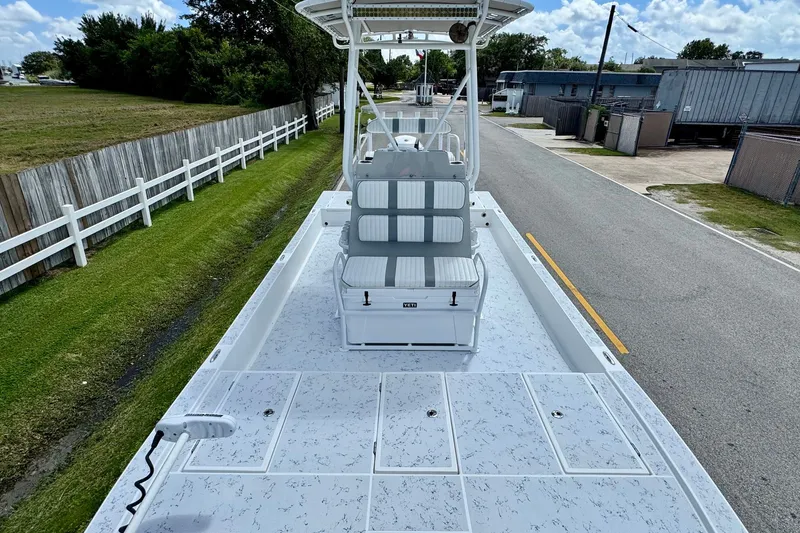Slide: The Image of 2017 Shallow Sport 25 X3 boat with spacious deck and seating, parked on a street. - 15