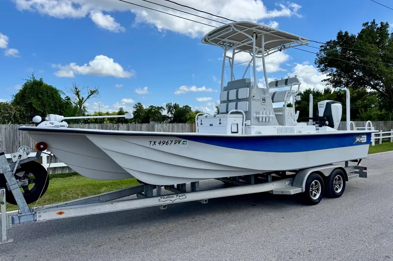 The Image of 2017 Shallow Sport 25 X3 boat on trailer, parked outdoors under a blue sky. - 1