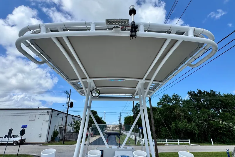 Slide: The Image of 2017 Shallow Sport 25 X3 boat with T-top under a clear blue sky. - 11