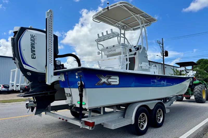 Slide: The Image of 2017 Shallow Sport 25 X3 boat on trailer with Evinrude engine, parked outdoors. - 4