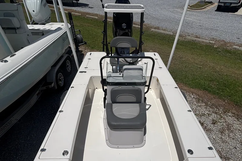 Slide: The Image of 2024 Spyder FX19 Vapor boat with seating and console, parked on gravel. - 6