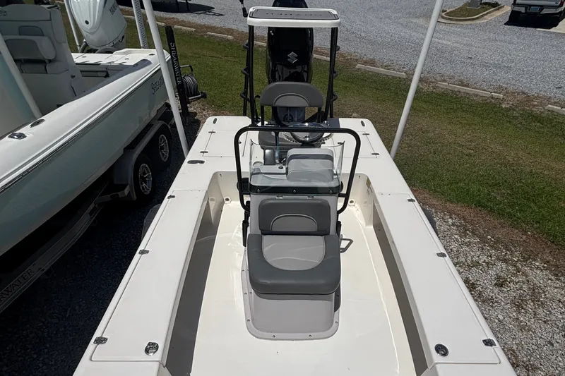 Slide: The Image of 2024 Spyder FX19 Vapor boat with seating and console, parked on gravel. - 7