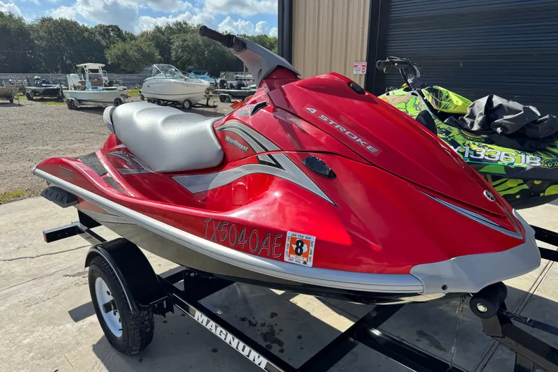 Slide: The Image of 2006 Yamaha WaveRunner VX110 Deluxe in red on a trailer, parked outdoors. - 4